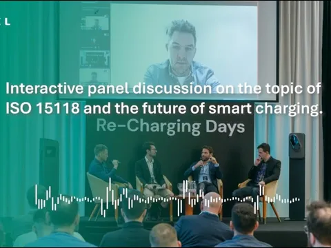 Four panellists seated on stage at Etrel's Re-Charging Days 2026 in Ljubljana, with a fifth joining remotely on the projection screen behind them.